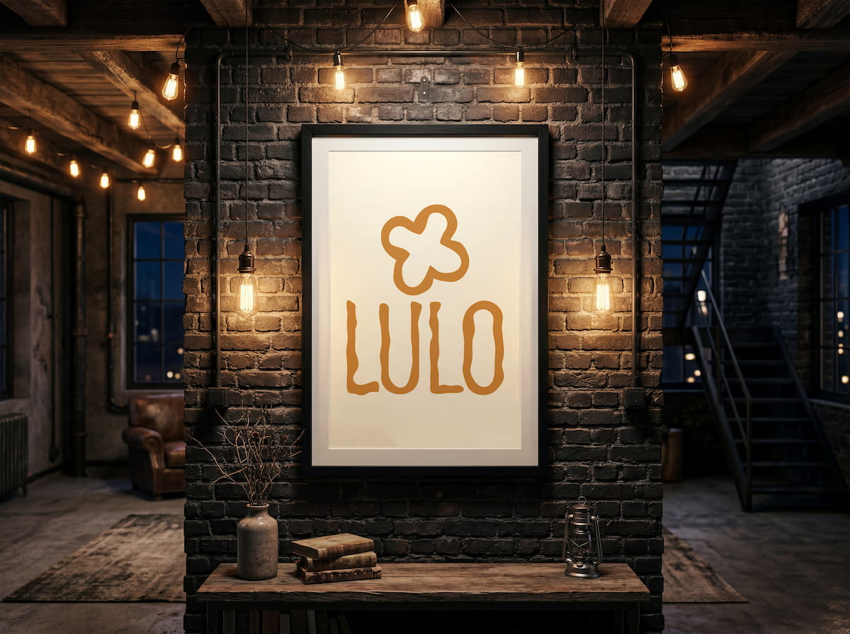 LULO logo in warm orange displayed in a framed print within a dark, warmly lit interior.